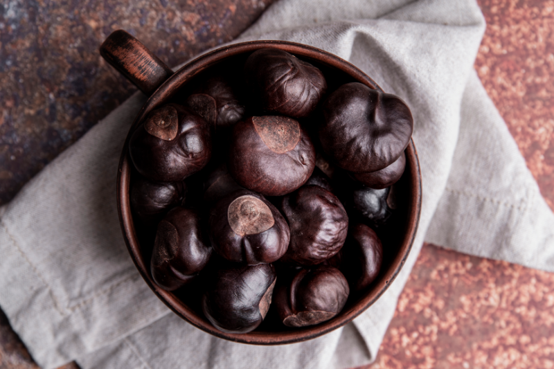 A bowl of fresh chestnuts showcasing their nutritional benefits, including low fat, high fiber, and complex carbohydrates for sustained energy.