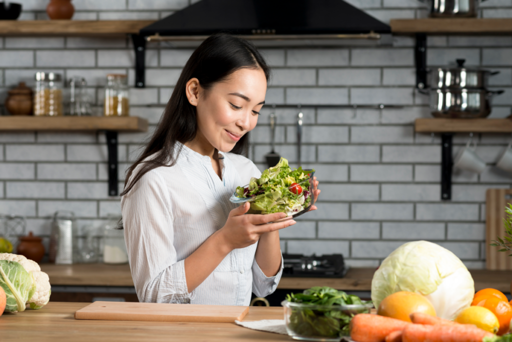 Woman measuring her waistline with a tape measure while healthy foods and a workout plan are on the table, symbolizing metabolic confusion for weight loss in 2025.